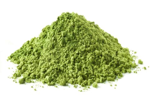 Kratom green powder stack on white background